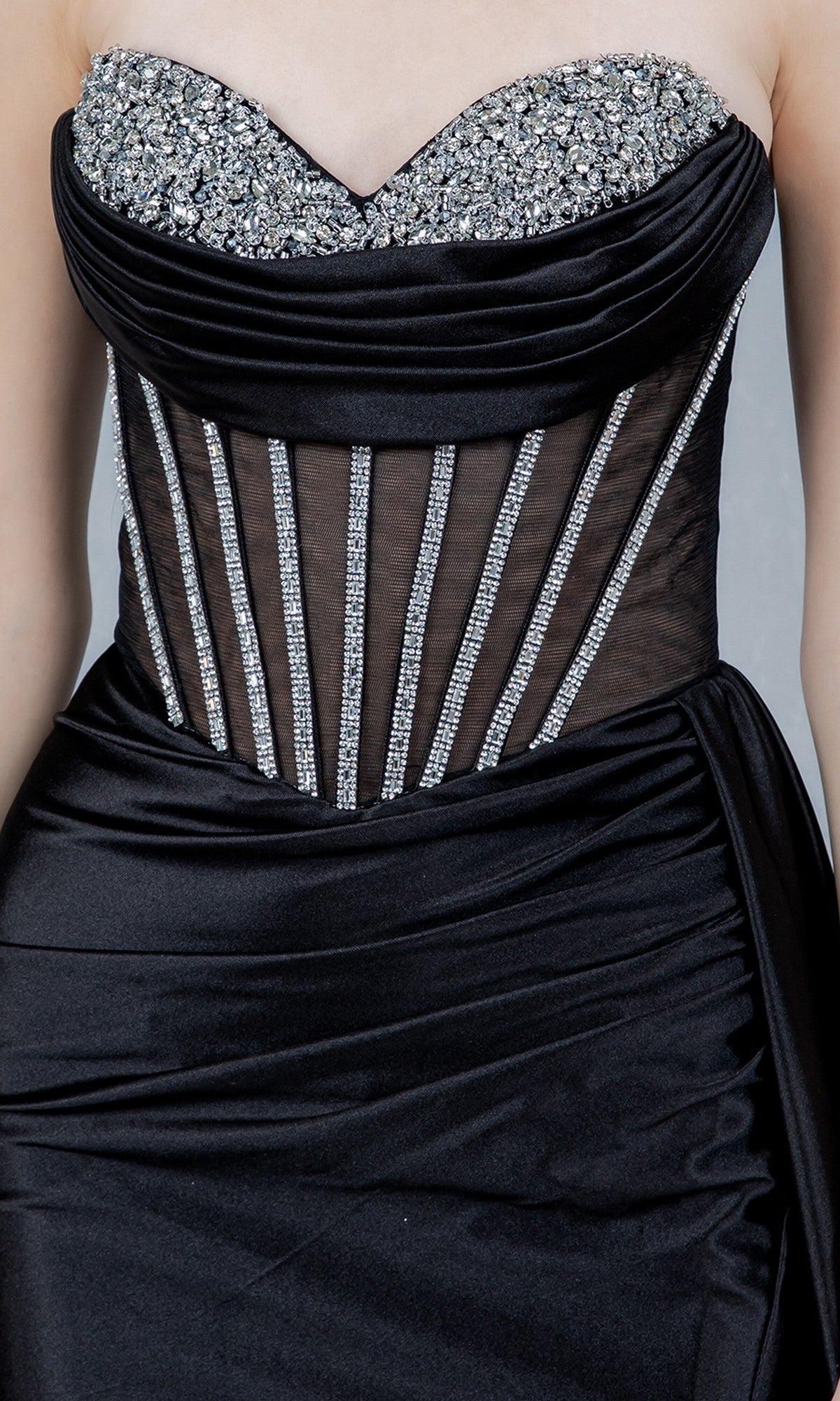A close-up of the Cinderella Couture 8454J long prom dress featuring a strapless black satin design with a sequined bodice, sheer paneling, and rhinestone accents.